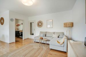 a living room with a couch and a table at Chiemsee Ferienwohnung Gartenblick in Prien am Chiemsee