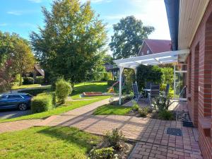 a patio with a white pergola on a house at Haus-Auetal in Bliedersdorf +68 photos