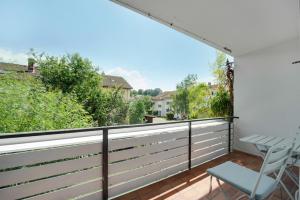 a balcony with a table and a chair on it at Chiemsee Ferienwohnung Gartenblick in Prien am Chiemsee