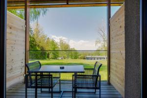 eine Terrasse mit Tisch und Stühlen und einem großen Fenster in der Unterkunft Hotel Ottenstein - Das Wohlfühlhotel in Rastenfeld