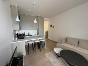 a kitchen and living room with a couch and a table at Zenith Lux Apartment Beachfront & Parking in Bijela