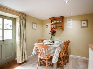 a dining room with a table and chairs at Fern Cottage in Bradwell