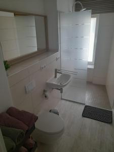 a bathroom with a toilet and a sink at Ferienwohnung Gertraude in Markranstädt +12 photos