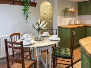 a kitchen with a white table with chairs and a tableasteryasteryasteryasteryastery at River View in Lazonby