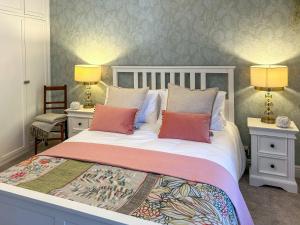 a bedroom with a bed with two tables and two lamps at River View in Lazonby