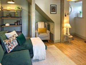 a living room with a green couch and a chair at River View in Lazonby