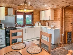 a kitchen with white cabinets and a table and chairs at The Lodge - Uk50721 in Aldbrough
