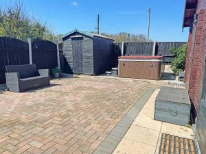 a patio with a barbecue grill and a fence at The Lodge - Uk50721 in Aldbrough