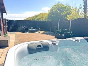 a bath tub with water in a backyard at The Lodge - Uk50721 in Aldbrough