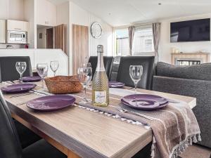 a dining table with a bottle of wine and glasses at Sunset Lodge in Lancaster