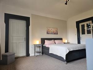 a bedroom with a bed with pink pillows at Ferienhof Dahl in Wurster Nordseeküste