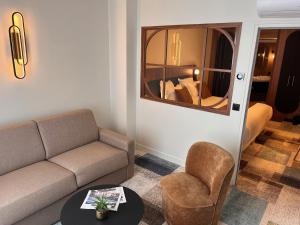 a living room with a couch and a chair and a mirror at Hôtel Le Yachtman, The Originals Collection in La Rochelle