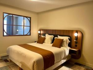 a bedroom with a large bed and a window at Hôtel Le Yachtman, The Originals Collection in La Rochelle