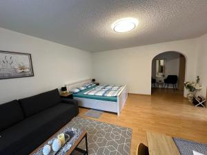 a living room with a couch and a bed at Ferienwohnung Kraus 2-4 Pers in Herbolzheim