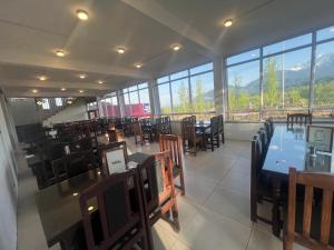 a dining room with tables and chairs and windows at gulmarg peak view resort in Gulmarg