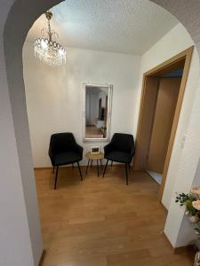 a hallway with two chairs and a mirror at Ferienwohnung Kraus 2-4 Pers in Herbolzheim