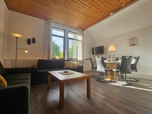 a living room with a couch and a table at Ferienhof Dahl in Wurster Nordseeküste