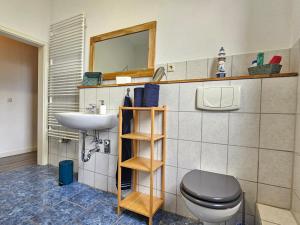 a bathroom with a toilet and a sink at Ferienhof Dahl in Wurster Nordseeküste +33 photos