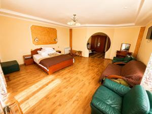 a living room with a bed and a couch at Hotel Jasmin All Inclusive in Truskavets