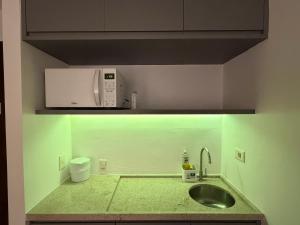 a kitchen with a sink and a microwave at Hotel Alameda Campinas Paulista in São Paulo
