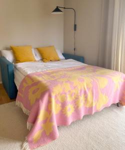 a bedroom with a bed with a pink and yellow blanket at LOEWENHERZ HOMES Mittenwald - Bijou in Mittenwald