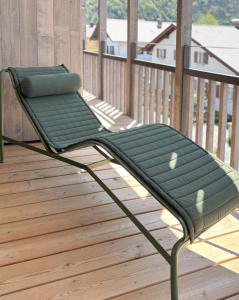 a green bench sitting on a wooden deck at LOEWENHERZ HOMES Mittenwald - Bijou in Mittenwald