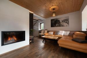 a living room with a couch and a fireplace at Chalet Dereše in Liptovský Mikuláš