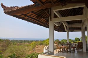 a patio with tables and chairs and a view of the ocean at Mimpi Manis Air Sanih in Kubutambahan