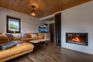 a living room with a couch and a fireplace at Chalet Dereše in Liptovský Mikuláš +19 photos