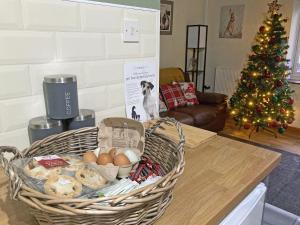 a basket of eggs on a table with a christmas tree at Teifi Cottage - Uk49590 in Llansawel