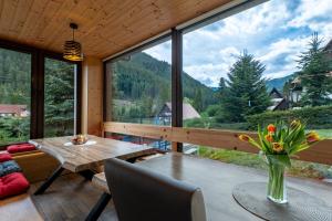 a room with a table and chairs and a large window at Chalet Dereše in Liptovský Mikuláš