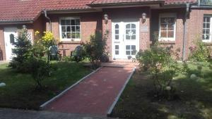 a brick house with a brick walkway leading to the front door at Ferienwohnung Zum Seeblick in Dahmen