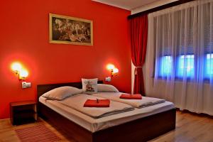 Dormitorio rojo con cama y ventana en Casa Nobilium, en Turda