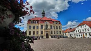 a large building with a red roof on a street at Ferienwohnung Grapatin in Teterow