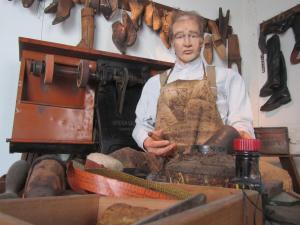 a woman in an apron standing next to a machine at Ferienwohnung Grapatin in Teterow