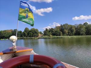 a flag on the back of a boat on a river at Ferienwohnung Grapatin in Teterow