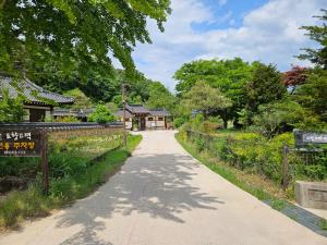 a walking path in a park with a building at Tohyang Traditional House in Bonghwa