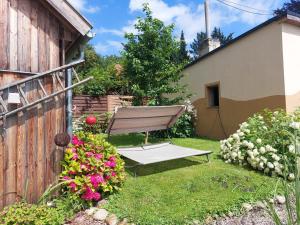 a bench in a yard with flowers and a fence at Ferienhaus Altes Kabinett in Schorssow +20 photos