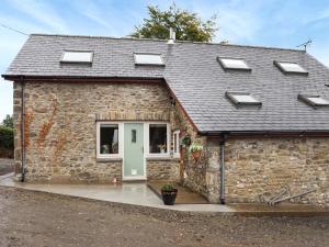 a stone house with a green door and windows at Cothi Cottage - Uk49588 in Llansawel