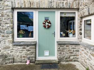 a blue door on a stone building with two windows at Cothi Cottage - Uk49588 in Llansawel +8 photos