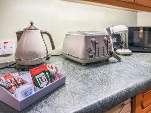 a toaster sitting on a counter next to a microwave at Cosy Neuk - Uk51345 in Peebles