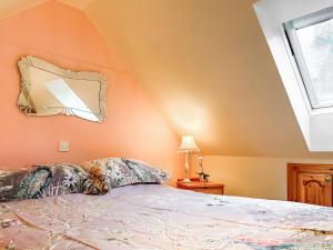 a bedroom with a bed with a mirror on the wall at Cosy Neuk - Uk51345 in Peebles