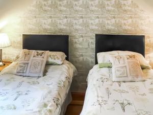 two beds sitting next to each other in a bedroom at Cosy Neuk - Uk51345 in Peebles