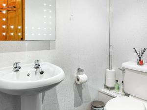 a white bathroom with a sink and a toilet at Cosy Neuk - Uk51345 in Peebles