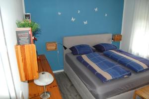 a bedroom with a bed with a blue wall at Ferienwohnung_Beethovenstrasse in Westerstede +13 photos