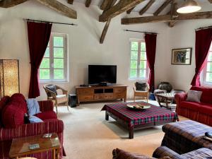 a living room with red furniture and a flat screen tv at Pion La Grange - cottage barn conversion in Castelnau-dʼAuzan