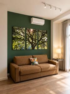 a brown couch in a living room with a tree painting at Apartamento Vista Jardim in São Domingos