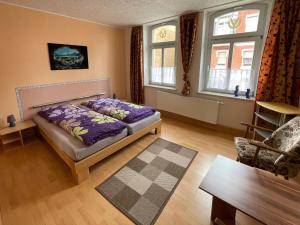 a bedroom with a bed and two windows at Ferienwohnung Gleißner Hartmann in Sangerhausen