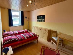 a bedroom with a bed and a table and a window at Ferienwohnung Gleißner Hartmann in Sangerhausen
