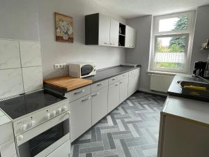 a kitchen with white cabinets and a counter top at Ferienwohnung Gleißner Hartmann in Sangerhausen +7 photos